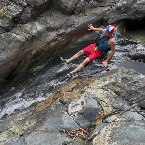 Sliding down the rock waterslide in the forest